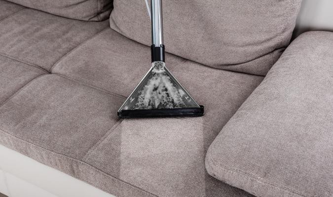 A grey sofa being deep cleaned