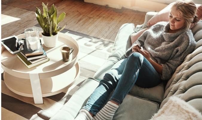 Woman getting comfortable on a sofa