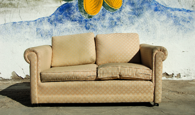Yellow fabric sofa with flat lumpy cushions