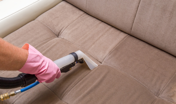Vacuuming brown microfiber sofa