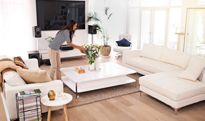 Woman watering plants in a cosy winter living room